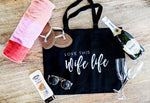 A black tote bag perfect for your honeymoon that says Love This Wife Life